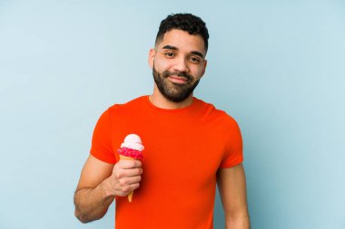 Dondurma tutan genç latin adam mutlu, güler yüzlü ve neşeli..
