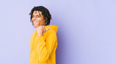 Genç Afro-Amerikan Rasta adamı parmağıyla işaret ediyor, gülüyor ve kaygısız..