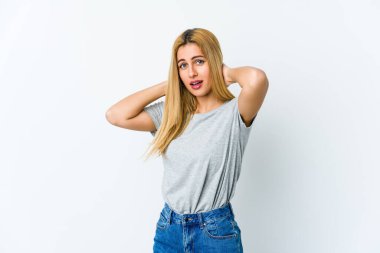 Beyaz arka planda izole edilmiş genç sarışın kadın kafasının arkasına dokunuyor, düşünüyor ve bir seçim yapıyor..