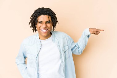 Genç Afrikalı Amerikalı Rasta adam işaret parmağıyla işaret ederek gülümsüyor..