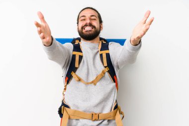 Beyaz arka planda izole edilmiş genç bir sırt çantalı adam kameraya sarıldığı için kendinden emin hissediyor..