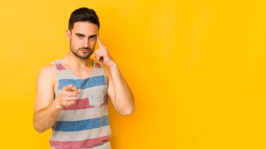 Kafkasyalı genç adam sarı fırında izole edilmiş, parmağıyla tapınağı işaret ediyor, düşünüyor ve bir göreve odaklanıyor..