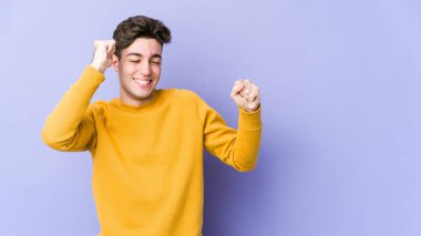 Genç beyaz adam mor arka planda izole edilmiş dans ediyor ve eğleniyor..