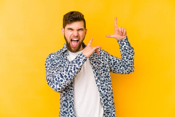 Genç beyaz adam sarı arka planda izole edilmiş dans ediyor ve eğleniyor..