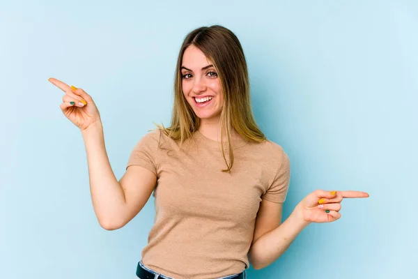 Jonge Blanke Vrouw Geïsoleerd Blauwe Achtergrond Wijzend Naar Verschillende Kopieerruimtes — Stockfoto