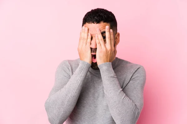 Homem Latino Jovem Contra Fundo Rosa Isolado Piscar Através Dedos — Fotografia de Stock