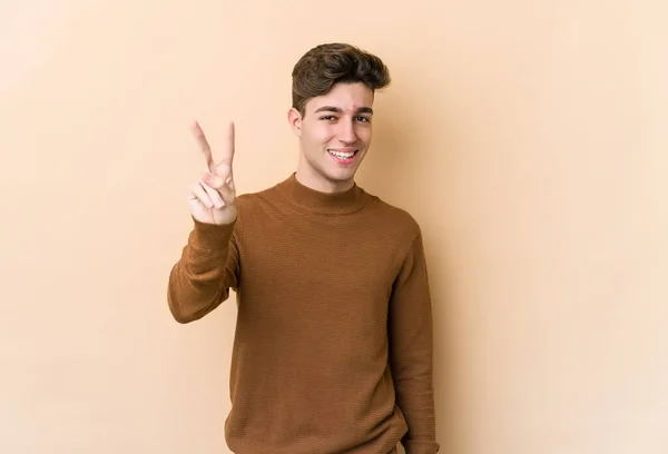 Jonge Blanke Man Geïsoleerd Beige Achtergrond Tonen Nummer Twee Met — Stockfoto