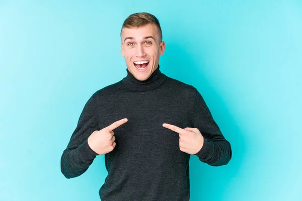 Jovem Caucasiano Fundo Azul Surpreendido Apontando Com Dedo Sorrindo Amplamente — Fotografia de Stock