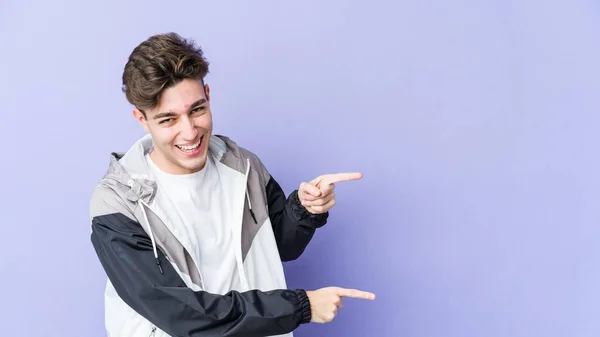 Young Caucasian Man Isolated Purple Background Pointing Forefingers Copy Space — Stock Photo, Image