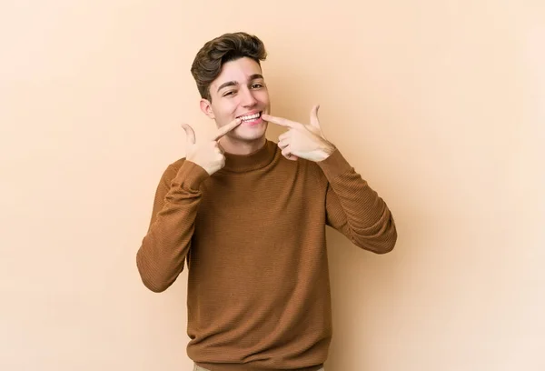 Young Caucasian Man Isolated Beige Background Smiles Pointing Fingers Mouth — Stock Photo, Image