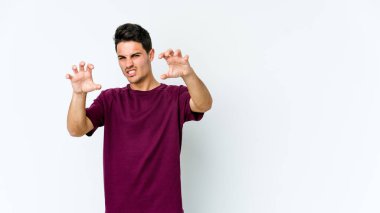 Beyaz arka planda izole edilmiş genç beyaz bir adam pençelerini kedi taklidi yaparken gösteriyor, agresif bir hareket..