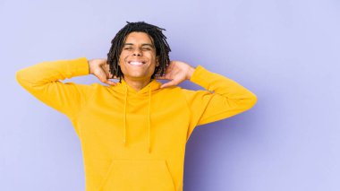 Genç Afro-Amerikan Rasta Adam kendini güvende hissediyor, elleri başının arkasında..