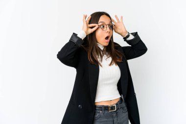 Genç, melez bir iş kadını beyaz arka planda izole edilmiş bir şekilde bir başarı fırsatı yakalamak için gözlerini açık tutuyor..