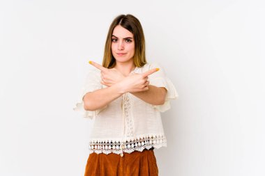Beyaz arka plan noktalarında izole genç beyaz kadın, iki seçenek arasında seçim yapmaya çalışıyor.
