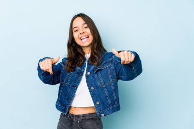 Latin kökenli genç bir kadın kendini soyutlamış. İki parmağını da kaldırmış, gülümsüyor ve kendinden emin..