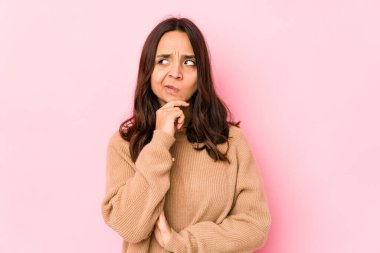 Latin kökenli genç bir kadın şüpheli ve şüpheci bir ifadeyle yanlamasına bakıyor..