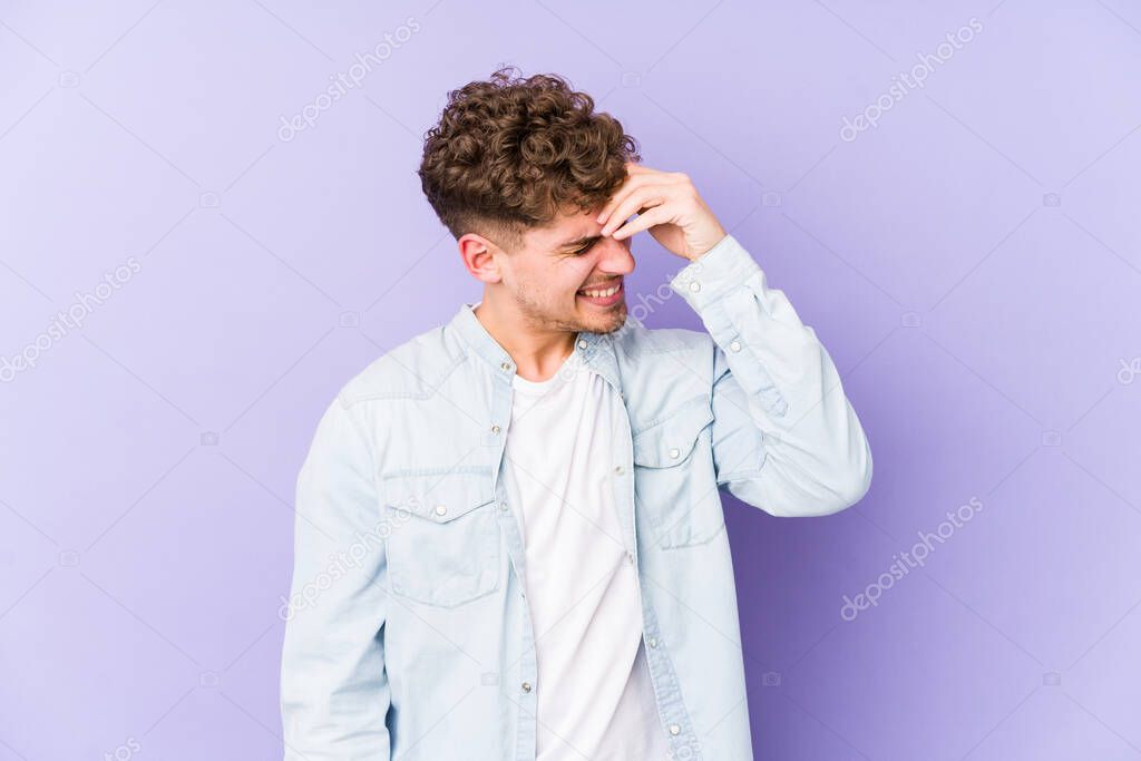 Young blond curly hair caucasian man isolated forgetting something, slapping forehead with palm and closing eyes.