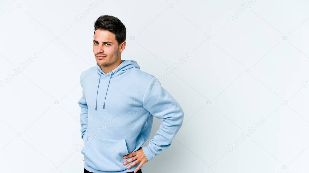Young caucasian man isolated on white background frowning face in displeasure, keeps arms folded.
