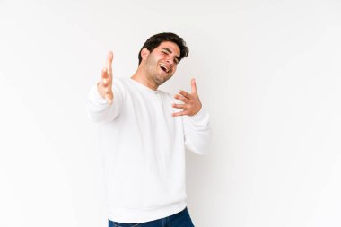 Beyaz arka planda izole edilmiş genç adam kameraya sarıldığı için kendinden emin hissediyor..