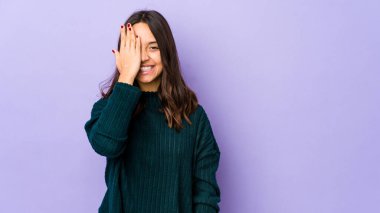 Genç, melez İspanyol bir kadın izole edilmiş, yüzünün yarısını avuç içiyle kaplayarak eğleniyor..