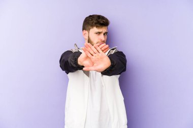 Mor arka planda izole edilmiş genç bir adam elini uzatmış, dur işareti gösteriyor, bu da seni engelliyor..