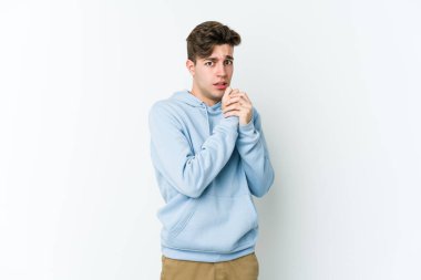 Beyaz arka planda izole edilmiş genç beyaz adam korkmuş ve korkmuş..