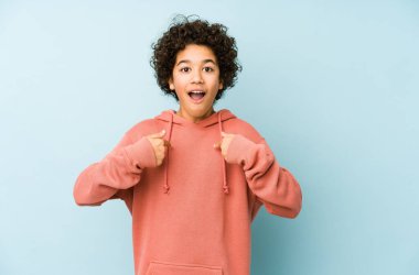 Afro-Amerikalı küçük çocuk kendini izole edip parmağını göstererek şaşırdı ve gülümsedi..