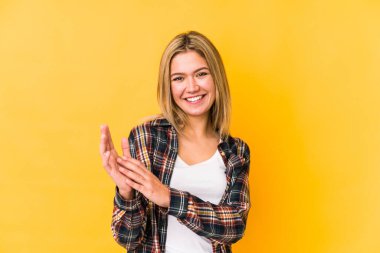 Sarışın, beyaz bir kadın, sarı arka planda izole edilmiş enerjik ve rahat hissediyor, ellerini ovuşturuyor..