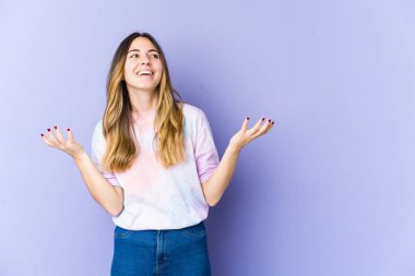 Genç beyaz kadın, mor arka planda izole edilmiş neşeli bir şekilde gülüyor. Mutluluk kavramı.