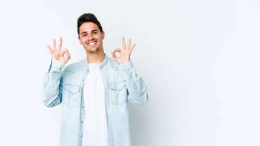 Beyaz arka planda izole edilmiş genç beyaz bir adam neşeli ve kendinden emin..