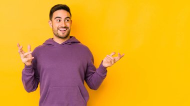 Kafkasyalı genç adam sarı fırında yapayalnız, neşeli bir şekilde gülüyor. Mutluluk kavramı.