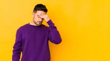 Kafkasyalı genç adam sarı fırında izole edilmiş, başı ağrıyor, yüzüne dokunuyor..