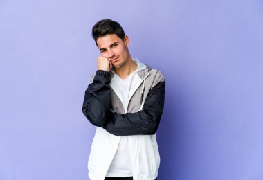 Mor arka planda izole edilmiş genç beyaz adam üzgün ve dalgın hissediyor, kopyalama alanına bakıyor..