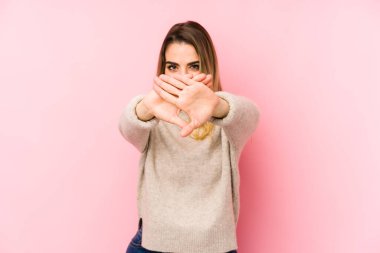 Pembe arka planda izole edilmiş orta yaşlı bir kadın inkar jesti yapıyor.