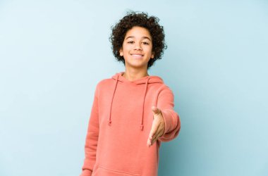Afrikalı Amerikalı küçük çocuk kameraya elini uzatarak selam veriyor..