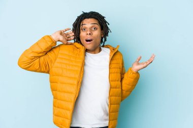 Genç melez adam, avuç içinde fotokopi alanı tutuyor, el üstünde tutuyor. Şaşırmış ve mutlu..