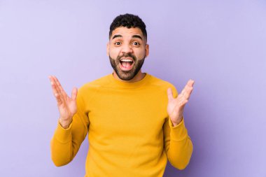 Genç, melez Arap bir adam zaferi ya da başarıyı kutluyor, şaşırıyor ve şok oluyor..