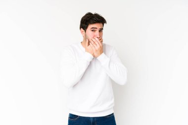 Genç adam beyaz arka planda izole edilmiş, ağzı kapalı ve elleri endişeli görünüyor..