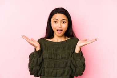 Pembe arka planda yaşayan genç Çinli kadın şaşırdı ve şok oldu..