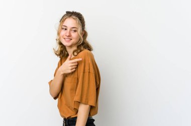 Beyaz arka plandaki genç beyaz kadın gülümseyen, neşeli ve keyifli bir kenara bakar..