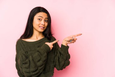Pembe arka planda izole edilmiş genç Çinli kadın işaret parmağıyla fotokopi alanını işaret ederek şok oldu..