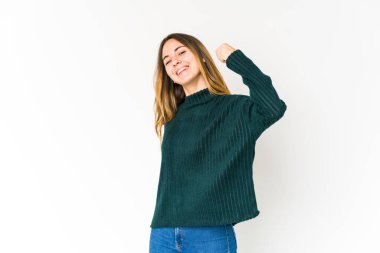 Beyaz arka planda yalnız kalmış, tasasız ve heyecanlı genç bir beyaz kadın. Zafer konsepti.