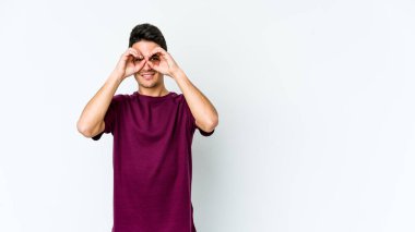 Beyaz arka planda izole edilmiş genç beyaz bir adam gözlerinde sorun olmadığını gösteriyor.