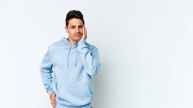 Beyaz arka planda izole edilmiş, üzgün ve dalgın hisseden genç beyaz bir adam fotokopi alanına bakıyor..