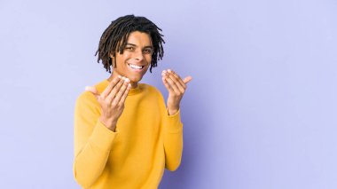 Rasta saç stili giyen genç siyahi adam seni işaret ediyor. Sanki davet ediliyormuş gibi..