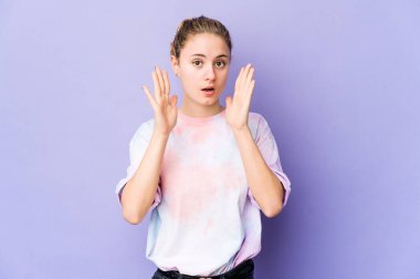 Mor arka plandaki genç beyaz kadın şaşırdı ve şok oldu..