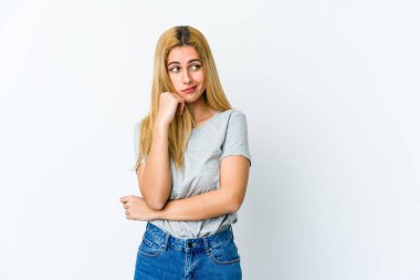 Beyaz arka planda soyutlanmış genç sarışın kadın kafası karışmış, şüpheli ve güvensiz hissediyor..