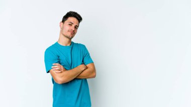 Beyaz arka planda izole edilmiş genç beyaz bir adam şüpheli, belirsiz, seni muayene ediyor..