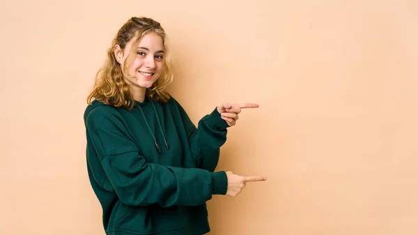 Ung Kaukasisk Kvinne Isolert Beige Bakgrunn Som Peker Med Pekefinger – stockfoto