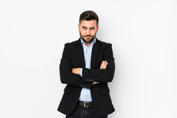 Young caucasian business man against a white background isolated frowning face in displeasure, keeps arms folded.